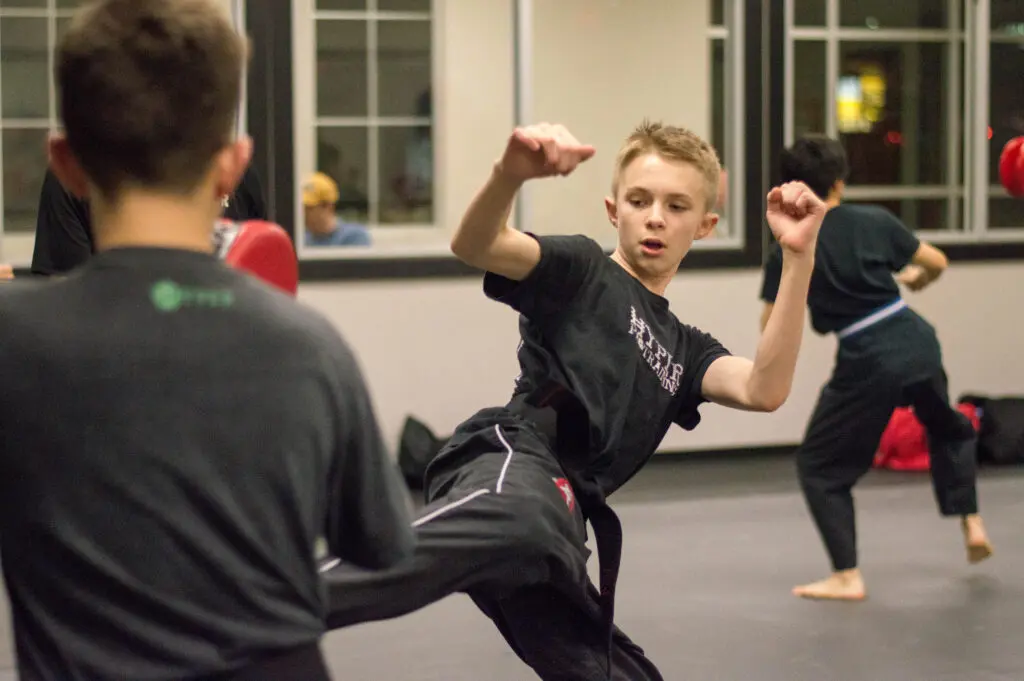 Teen using karate kick in pflugerville classes
